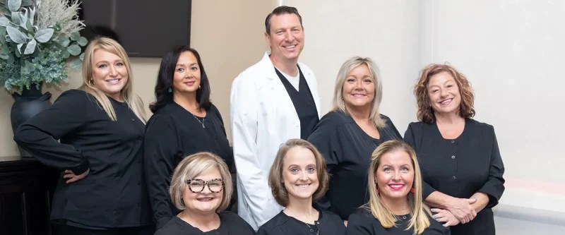 Dr. Stephen Wilson standing with the full dental staff of Stress Free Dentistry inside the office lobby.