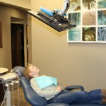 Young patient comfortably relaxing in a dental chair while watching a ceiling-mounted television screen at Stress Free Dentistry.